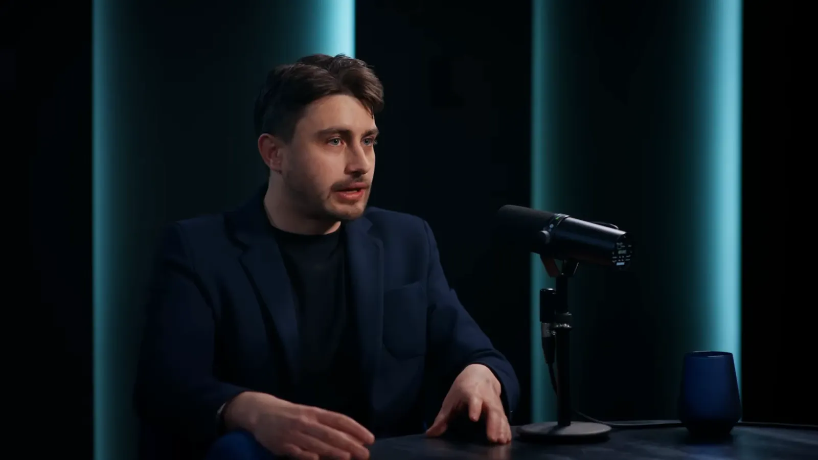 Vlad Tudor la masa podcastului, în timp ce vorbește