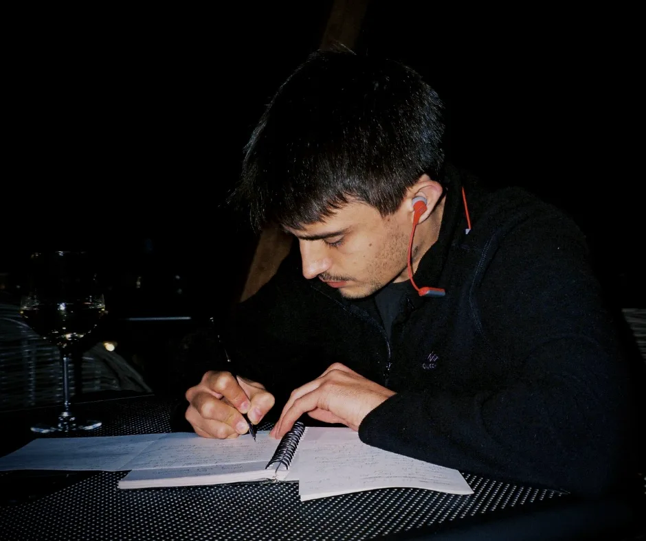 Writing in a notebook at night.